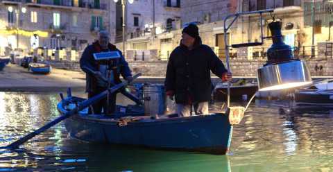 Una lampara per accecare i pesci e una fiocina per prenderli al volo:  l'antica "pesca a fuoco"  